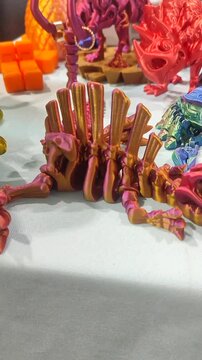 Small ichthyosaurus skeleton printed on 3D printer from molten plastic of pink orange color. Creative multicolored models printed on 3D printer. Concept 3D Printing. 3D Printing technology. Vertical