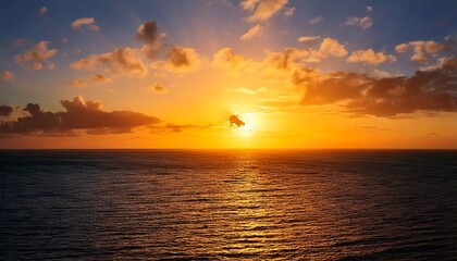 Golden sun sinks towards horizon, casting its warm glow upon vast ocean