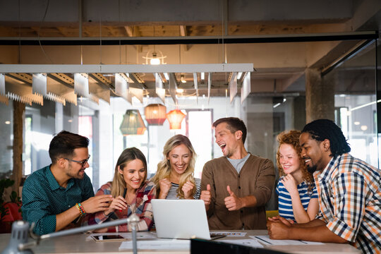 Group portrait of young startup business team celebrating success in the office