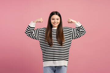 Attractive, smiling girl showing strength and confidence on pink background