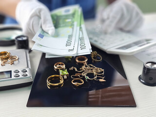 Evaluating jewelry while handling euro banknotes and weighing precious items