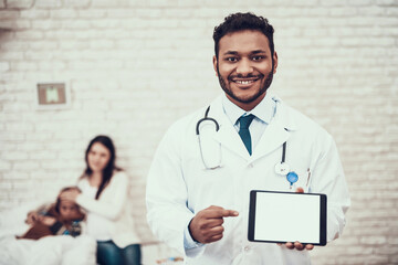 Indian doctor seeing patients at home. Doctor is posing with tablet with pregnant mother and...