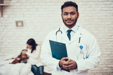 Indian doctor seeing patients at home. Doctor is posing with tablet with pregnant mother and...