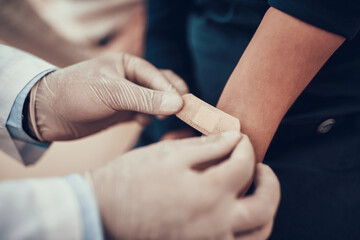 Obraz premium Indian doctor seeing patients in office. Doctor is putting patch on daughter's arm.