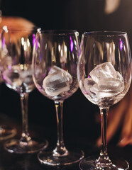 Bartender working, barman mixing and pouring drinks and beverages in a club, beautiful row line of different red coloured liquor alcohol cocktails on a party in a bar, catering banquet on event