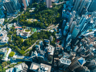 Aerial panorama of Hong Kong city showcasing dense buildings and vibrant green park amidst the...