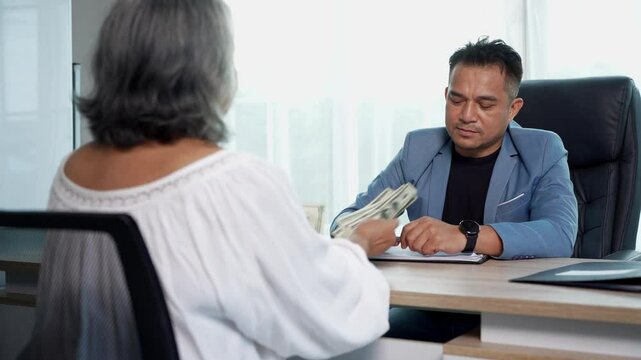 Medium shot, Businessman shake hand after agree deal with Us dollar money in his hand, accept bribe from female client in contracting. Corruption and anti bribery concept
