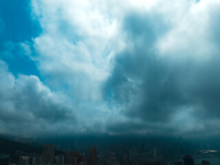 Aerial panorama of Hong Kong city under a dramatic sky filled with dense clouds.  A high-angle view...