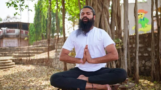 Bearded devotee practices yoga in lotus position