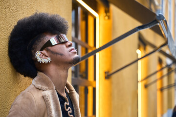 Fashionable afro gay androgynous model posing in urban setting