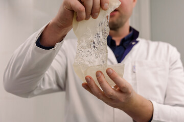 A plastic surgeon holds breast implants in his hands