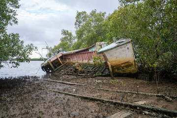  A once proud wooden boat sits on the waters edge slowly decaying