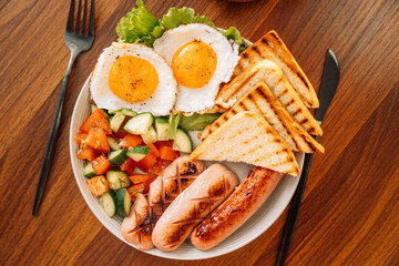 A hearty breakfast of fried eggs, sausages and toast.