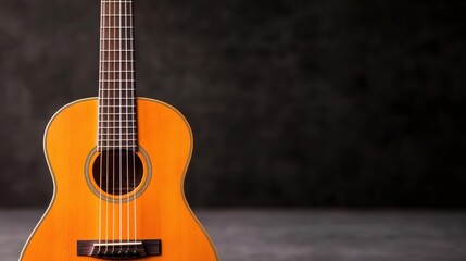 Obraz premium A beautifully crafted wooden guitar with a warm orange finish, set against a dark background, highlighting its elegant design and features.