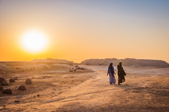 Two Afar women walking at sunset by lake Afdera in Afar region, Ethiopia