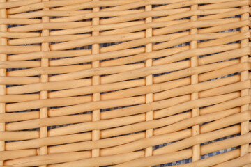 A close-up shot of woven rattan with a visible underlying fabric, creating a textured pattern