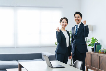 Fototapeta premium オフィスでガッツポーズする男女ビジネスパーソンのグループ