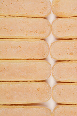 A close-up shot of ladyfinger biscuits arranged in a row, highlighting their texture and color