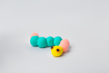 Caterpillar made from play dough on light grey background