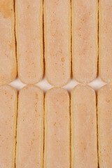 A close-up shot of ladyfinger biscuits arranged in a row, highlighting their texture and color
