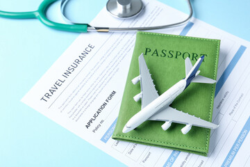 Medical tourism. Travel insurance application form, stethoscope, passport and plane model on light...