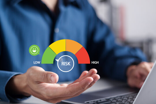 Risk management concept on speedometer. High risk of Business decision making and risk analysis. Businessman using laptop with Risk meter icon on virtual screen.