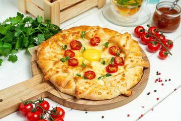 Pizza with cheese, egg and cherry tomatoes, restaurant. Horizontal frame.