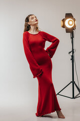 Young girl in red dress at studio on white background