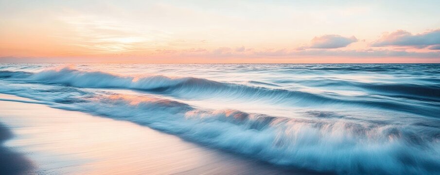 The ocean waves crashing gently on the sandy beach at sunset
