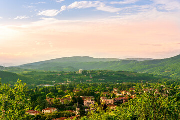 Naklejka premium travel summer view from hill to a nice european town with amazing buildings, green hills and mountains with amazing cloudy evening sky on background