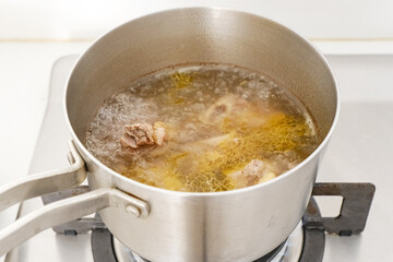Boiled beef ribs in stainless steel saucepan 
