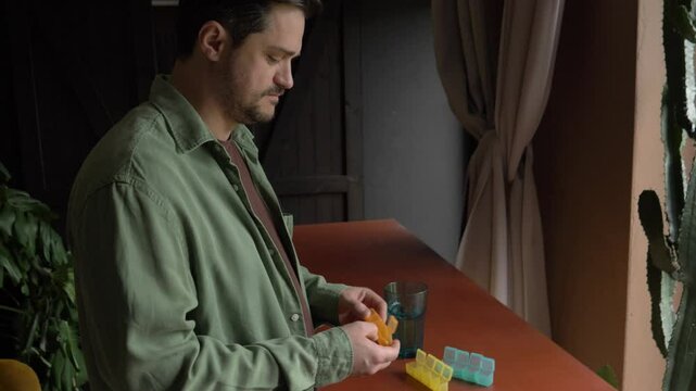 man drinks pills and vitamins with minerals, takes from sorter