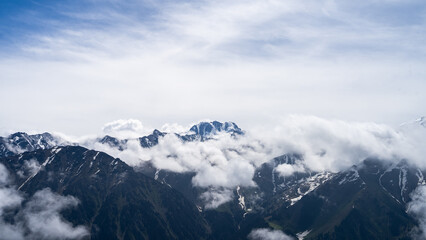 snowy mountain peaks in the clouds