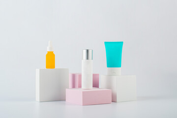 Packaging of cosmetics for self-care: cream, serum, lotion, cosmetic oil with stylish props on white background.