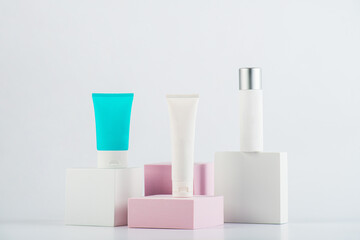 Plastic white tube for cream or lotion. Skin care or sunscreen cosmetic with stylish props on white background.