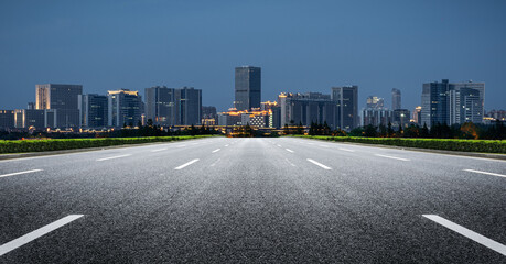 Expansive Urban Highway Leading to a Vibrant Skyline at Night