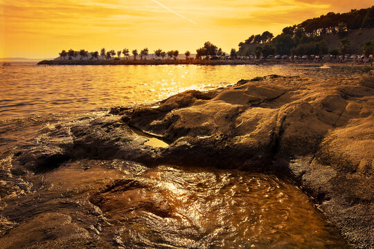 rocky shore of the Adriatic Sea in the golden rays of sunset