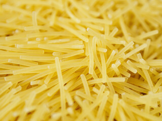 Close-up of small, thin vermicelli filini pasta. Delicate strands create a fine, textured food background.