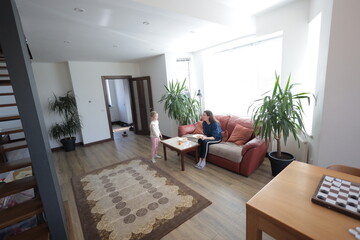 Mother and a child girl cooking and eating indoors together 