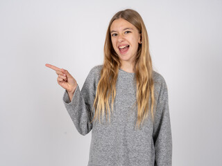 beautiful caucasian girl wearing grey track-suit  points aside on copy blank space. People promotion and advertising concept