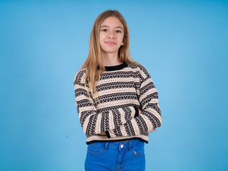 Portrait of charming beautiful caucasian girl wearing striped sweater standing confidently smiling toothily with hands folded