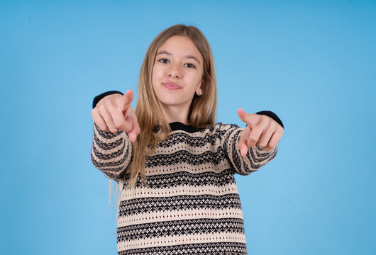 beautiful caucasian girl wearing striped sweater cheerful and smiling poiting at camera