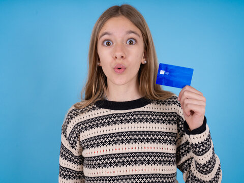 Photo of beautiful caucasian girl wearing striped sweater amazed shocked hold credit card payment
