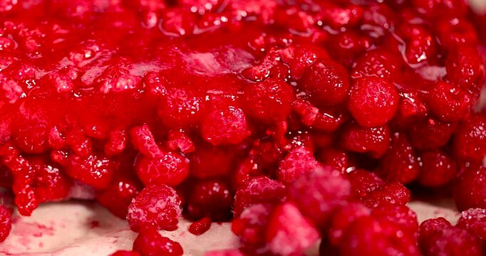 frozen sweet red raspberries for long-term storage, frozen red raspberries during their melting for dessert in winter closeup
