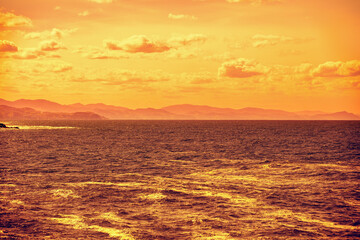 Cloudy sky over the sea at golden sunset. Abstract nature background. Donostia, San Sebastian, Basque Country, Spain