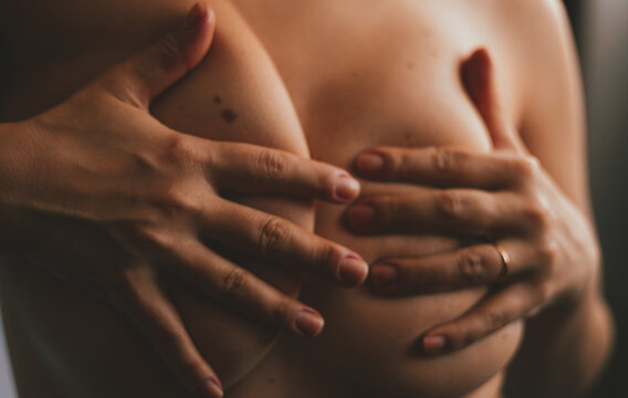 Passionate naked woman touching breasts