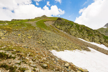 landscape with mountain and blue sky with clouds. steep hill with stones and grass. beautiful nature of romania in summer