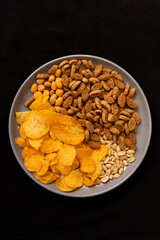 plate with beer snacks on black background