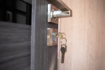 modern metal key on wooden door.