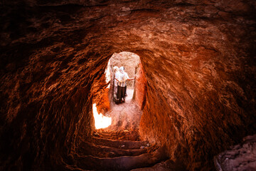 Girls walking through a tunnel connecting rock-hewn churches in Lalibela, Ethiopia